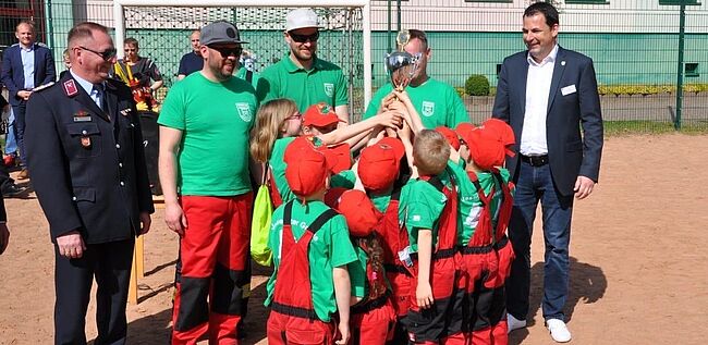 Landkreis Börde / Dezernent Uwe Baier (rechts im Bild) und Kreisbrandmeister Matthias Schumann durften in Arendsee an die an die drittplatzierte Mannschaft im Orientierungsmarsch "Rund um den Arendsee" aus Jeseritz einen Pokal überreichen