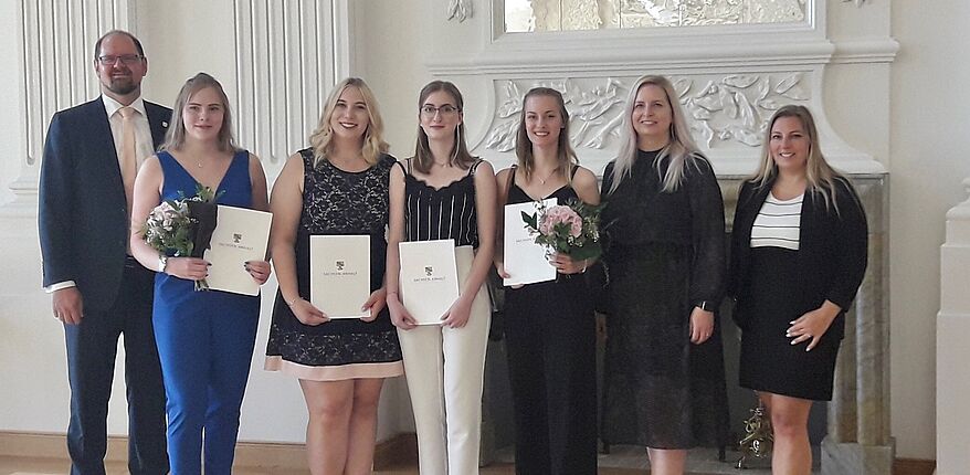 Foto Landkreis Börde / Aufstellung zum Erinnerungsfoto (v.l.n.r.) Landrat Martin Stichnoth, Carry Schwarze, Leonie Wagner, Miriam Niechoy, Lara Strauß Personalcheffin Julia Herzberg-Ebeling und Ausbildungsleiterin Manuela Brasch