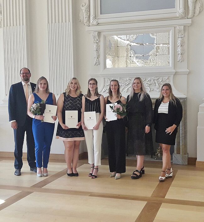 Foto Landkreis Börde / Aufstellung zum Erinnerungsfoto (v.l.n.r.) Landrat Martin Stichnoth, Carry Schwarze, Leonie Wagner, Miriam Niechoy, Lara Strauß Personalcheffin Julia Herzberg-Ebeling und Ausbildungsleiterin Manuela Brasch