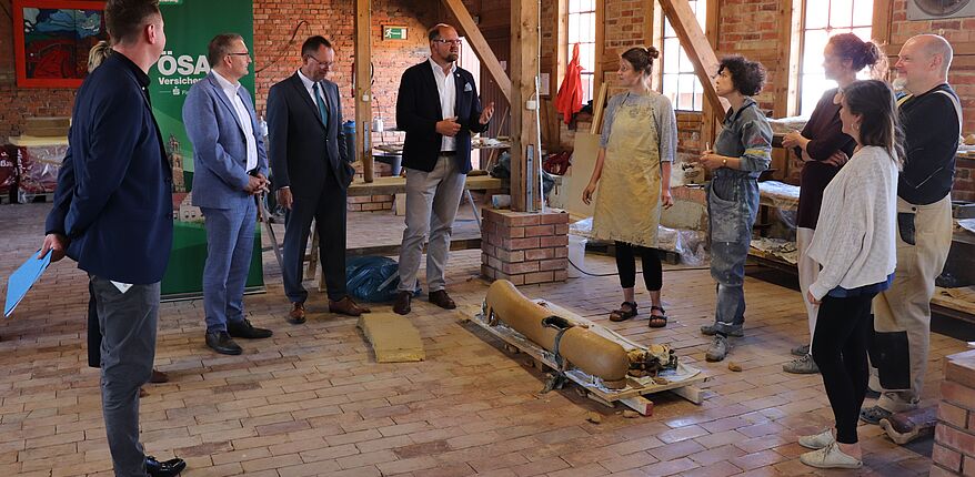 Foto Uwe Baumgart / Aufstellung zum Erinnerungsfoto mit Landrat Martin Stichnoth und den Verantwortlichen der ÖSA, 5 der 6 Künstler waren zum Termin anwesend, von links nach rechts sind das Julia Himmelmann, Jana Mertens, Judith Runge, Katie Lagast (Portugal) und Olaf Stoy, nicht im Bild Marianne Eggimann. Das Foto ist in der großen Atelierscheune in Hundsiburg entstanden.