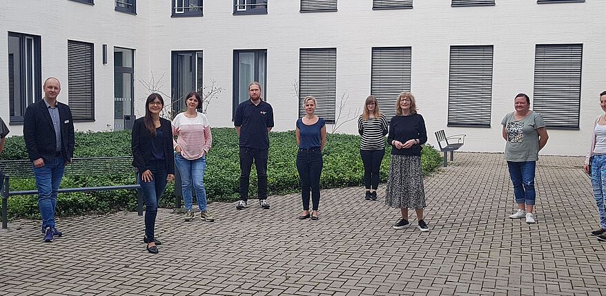 Das Foto im Innenhof des Verwaltungsgebäudes des Landkreises Börde in Haldensleben zeigt unter Einhaltung der Abstandsregel 10 Personen, die im Netzwerk Familie mitarbeiten. Unter anderem Katja Klommhaus, Gleichstellungsbeauftragte des Landkreises Börde.