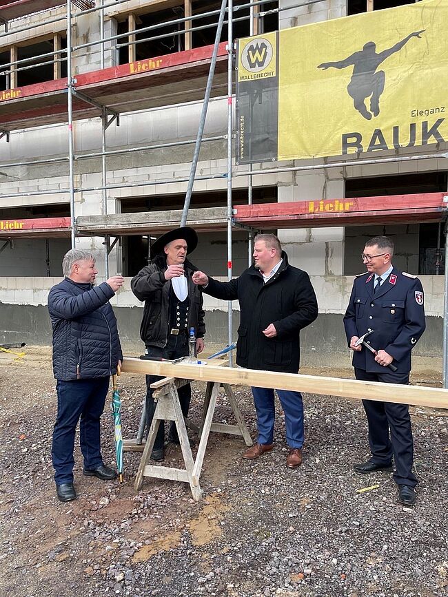 Foto Landkreis Börde / zum Richtspruch erhebt Barlebens Bürgermeister Frank Nase das Glas.