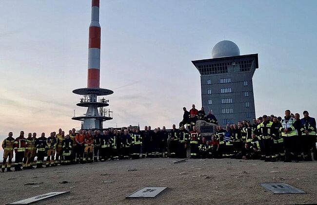 Foto Landkreis Börde / am späten Sonntagabend war der Einsatzauftrag für die Helfer aus dem Landkreis Börde erfolgt / sie wurden durch frische Kräfte abgelöst. Hier Aufstellung zum Erinnerungsfoto auf dem Brockengipfel. 