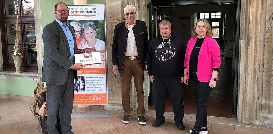 Foto Landkreis Börde / Landrat Martin Stichnoth gratuliert Betreibern des Betreuungszentrum zum Jubiläum. Mit einer Schachtel "Merci" in der Hand sagt der Landrat danke. 
