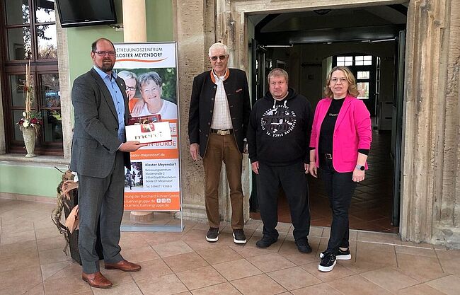 Foto Landkreis Börde / Landrat Martin Stichnoth gratuliert Betreibern des Betreuungszentrum zum Jubiläum. Mit einer Schachtel "Merci" in der Hand sagt der Landrat danke. 