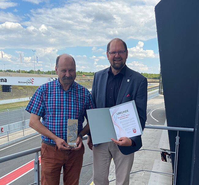 Foto Landkreis Börde / stellvertretend für ein großes Team gratuliert Landrat Martin Stichnoth Arena-Geschäftsführer Ralph Bohnhorst zum 25-Jährigen Jubiläum. Stichnoth überreicht eine Urkunde und einen Pokal. 