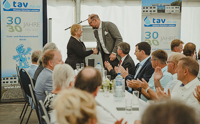 Foto Trink- und Abwasserverband Oschersleben (TAV) / 30 Jahre TAV - viele Gäste nutzen in diesen Tagen die Festveranstaltung des Verbandes, um zu gratulieren. Im Bild, Verbandsgeschäftsführerin Vinny Zielske nimmt die Glückwünsche des Landrates entgegen. 