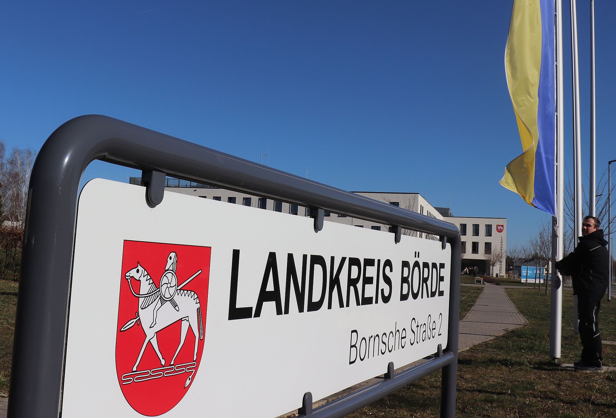 Das Foto zeigt die ukrainische Flagge am Flaggenmast des Landkreises Börde in Haldensleben. Im Hintergrund das Verwaltungsgebäude des Landkreises Börde.