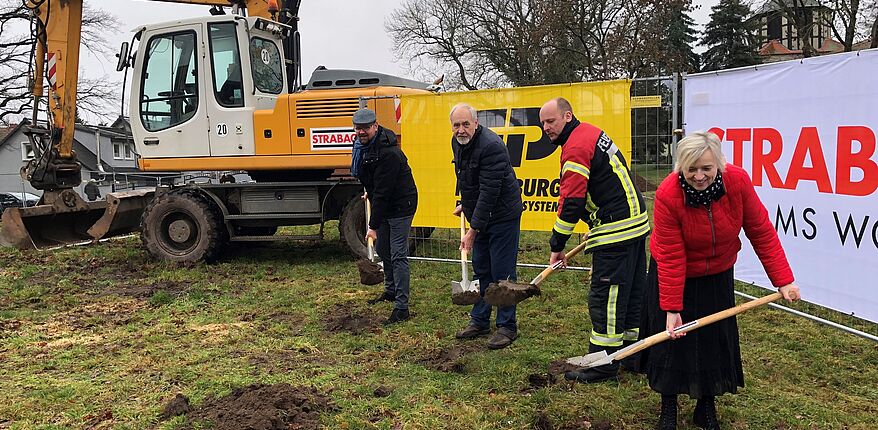 Das Foto zeigt 4 Personen mit einen Spaten in der Hand. Hintergrund, sie vollziehen den ersten Spatenstich für den Neubau des Feuerwehrgerätehauses in Farsleben. Im Bild unter anderem Wolmirstedt´s Bürgermeisterin Marlies Cassuhn und Landrat Martin Stichnoth. 