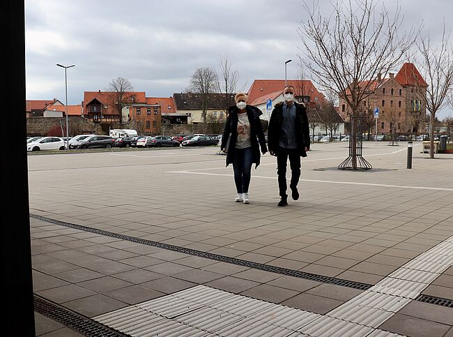 Foto Uwe Baumgart / zunächst bis zum 22. April 2022 bleibt das Tragen einer medizinischen "Mund-Nasen-Bedeckung" für Besucher der Verwaltungsgebäude des Landkreises Börde verpflichtend. Auf dem Foto kommen 2 Besucher mit FFP2-Maske in das Haldensleber Verwaltungsgebäunde. Im Hintergrund sieht man die Stadt mit Kirchturm und Stendaler Torturm. 