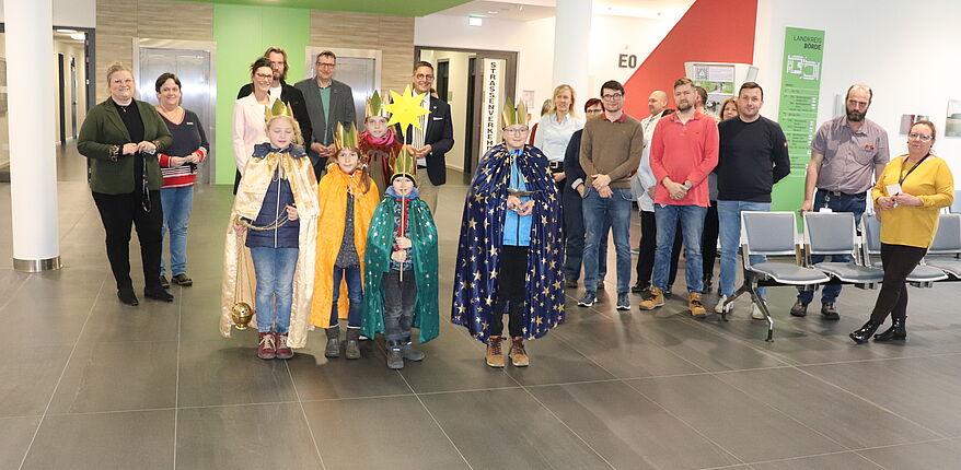 Foto Uwe Baumgart / die Sternsinger segnen das Verwaltungsgebäude des Landkreises Börde. Beschäftigte der Verwaltung sind gekommen, um zu spenden.